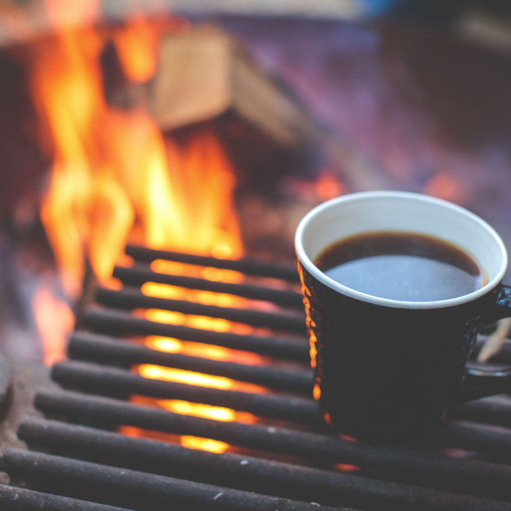 coffee cup next to campfire